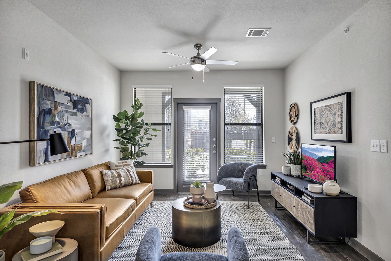 a living room with a couch and a ceiling fan